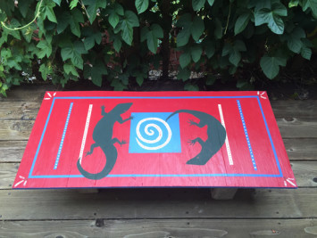 Hand-painted lizards make an upcycled plywood tabletop